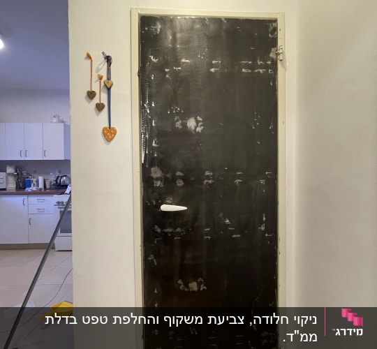 דלת מצופה בצבע כהה בתהליך צביעה